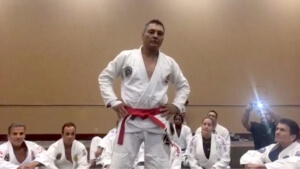 A man in white and red belt doing a karate move.