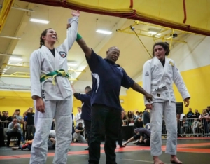 A man and two women are holding hands in the air.