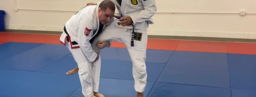 Two men in white and black uniforms practicing bjj.