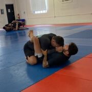 Two men are practicing their moves on a mat.