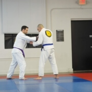 Two men in white and blue uniforms practicing martial arts.