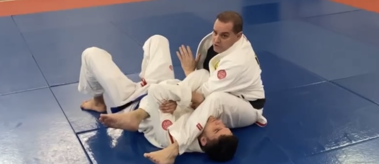 Two men are practicing judo on a blue mat.