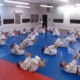 A group of people in white and blue uniforms doing martial arts.