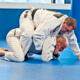Two men in white and black uniform practicing bjj.