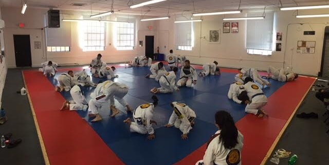 A group of people in the gym practicing martial arts.
