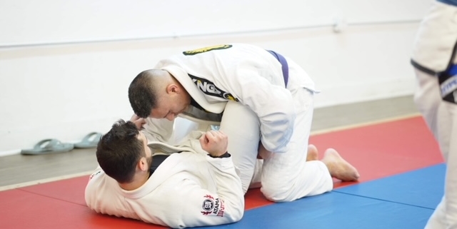 Two men are practicing judo on a mat.