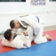 Two men are practicing judo on a mat.