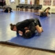 A woman is wrestling on the ground in a gym.