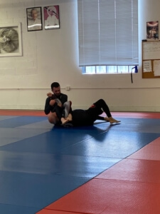 Two men are practicing martial arts on a mat.