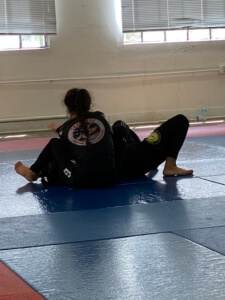 A person is sitting on the ground in a wrestling position.