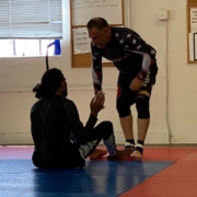 A man and woman are wrestling on the floor.