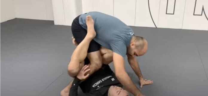 Two men are wrestling on the floor in a room.