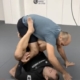 Two men are wrestling on the floor in a room.