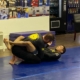 Two people are practicing jiu jitsu on a mat.