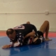 A man is wrestling on the ground in an indoor gym.