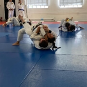 A group of people practicing martial arts on mats.