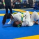 A woman is wrestling on the ground in a competition.