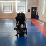 A group of people practicing martial arts in an indoor gym.