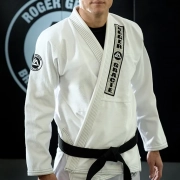 A man in white and black uniform standing next to a wall.