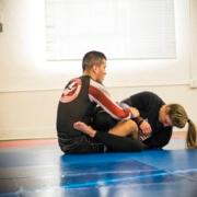 Two people are practicing martial arts on a mat.