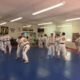 A group of people in white and yellow uniforms practicing martial arts.