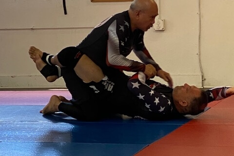 A man is wrestling another man on the ground.