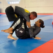 Two people are practicing martial arts on a mat.