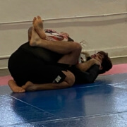 A man is wrestling on the ground in a gym.