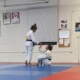 Two people in a judo gym one is holding a board