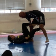 Two men are practicing martial arts in a gym.