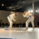 Two men in white and blue uniforms are performing a judo move.