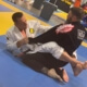 Two men are practicing jiu jitsu on a mat.