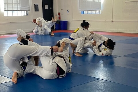 A group of people practicing martial arts in an indoor gym.