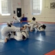 A group of people practicing martial arts in an indoor gym.