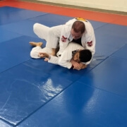 A man is wrestling on the ground in a gym.