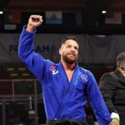 A man in blue and black uniform holding his fist up.