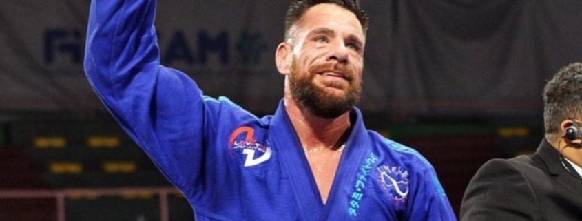 A man in blue and black uniform holding his fist up.