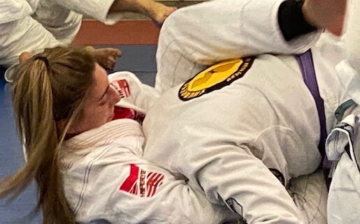 A woman is on the ground in a judo match.