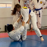 A woman is doing judo moves on the ground