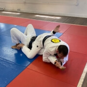 A man in white and black uniform on red mat.