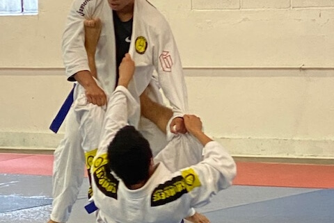 A man is doing judo moves on another person.