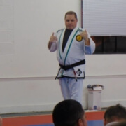 A man in white and black uniform giving a presentation.