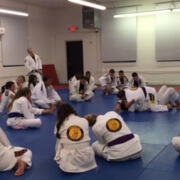 A group of people sitting on the floor in a room.