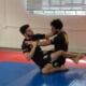 Two men are practicing martial arts in a gym.