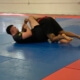 A man is wrestling on the ground in a gym.
