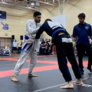 Two men in a judo match, one of them trying to kick another man.